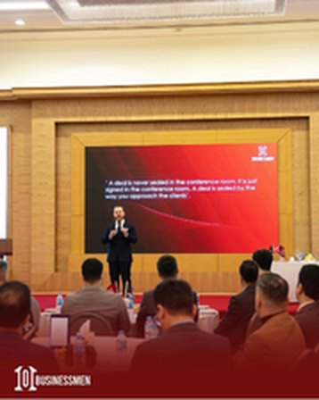 A speaker presenting on stage at a 1001 Businessmen session