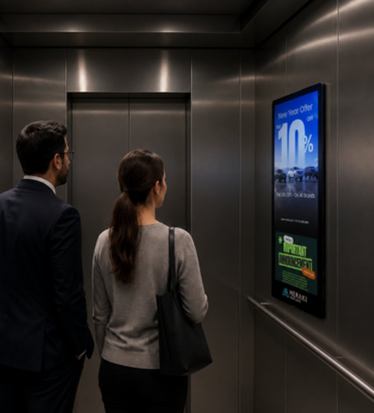 Two professionals viewing a Meraki Ventures advertising screen inside an elevator